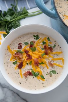 a bowl of keto meal plan with cheese and bacon on top, next to a spoon