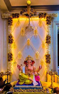 an elephant statue sitting on top of a table in front of a chandelier