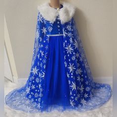 a blue dress with white snowflakes on it and a fur collar around the neck