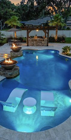 an outdoor pool with lounge chairs and fire pit