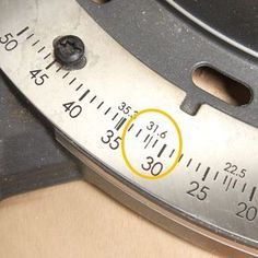 a close up of a metal ruler with yellow circle on it's center and two holes in the middle