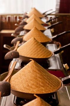 a row of pots and pans with straw hats on them