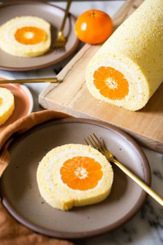 two plates with oranges on them next to some bread and an orange slice in the middle