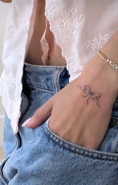 a woman's hand with a small tattoo on it