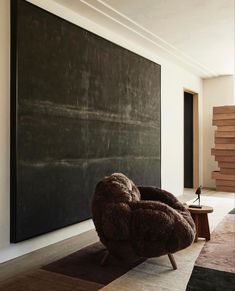 a chair sitting in front of a blackboard with stairs on the wall behind it