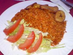 a white plate topped with lots of food on top of a red table cloth next to utensils