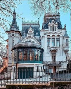 a large white house with two towers on top of it's roof and windows