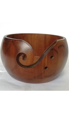 a wooden bowl sitting on top of a white table