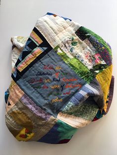 a piece of art made out of old quilts with words written on the side