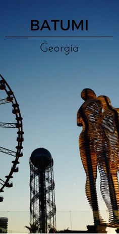 the silhouettes of two people in front of a ferris wheel