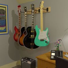 three guitars are hanging on the wall next to a radio and a guitar rack in an office