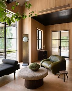 a living room with wood paneling and leather furniture