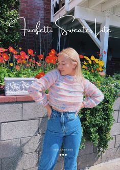 a woman standing next to a brick wall with her hands on her hips and looking at the camera