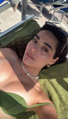 a woman laying on top of a towel next to a pool