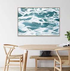 a table with two chairs and a painting on the wall above it in a dining room