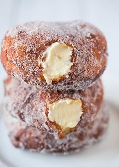 three donuts stacked on top of each other covered in powdered sugar and peanut butter