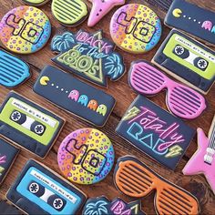 decorated cookies are laid out on a table with sunglasses, tape recorders and other items