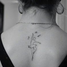 the back of a woman's neck with musical notes and a ballerina tattoo