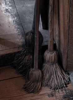 two brooms sitting next to each other on the floor