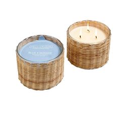 two wicker candles sitting next to each other on a white background, one with a blue lid