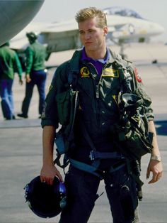 a man in an air force pilot's uniform is walking towards the camera