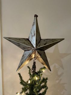 a metal star hanging from the side of a christmas tree