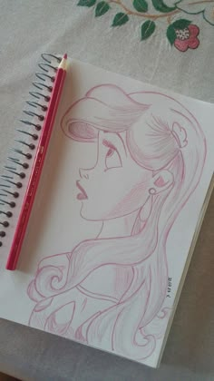 a drawing of a girl with long hair and a hat on her head is shown next to a pencil