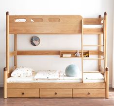 a wooden bunk bed with drawers underneath it and a clock on the wall behind it