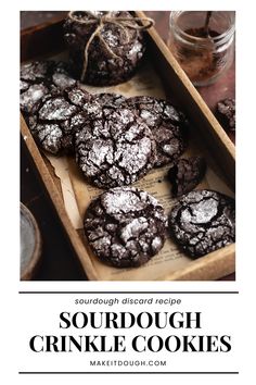 chocolate cookies with powdered sugar are in a wooden box and the title says sourdough crinkle cookies