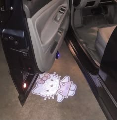 the interior of a car with hello kitty decal on the floor next to it