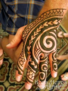 a person's hand is decorated with hennap and swirls on it