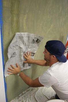 a man is painting the wall in his bathroom