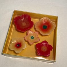 four red and white flowers on a yellow tray