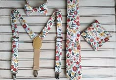 four piece set of floral print suspenders, bow tie and matching clip on wooden background