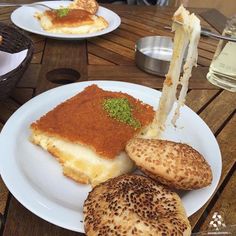 some food is on a white plate with bread and other foods are sitting on the table