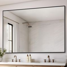 a bathroom with two sinks and a large mirror on the wall over it's sink