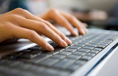 a person typing on a laptop keyboard with their hands resting on the keyboard and touching the keys