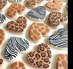 decorated cookies in the shape of hearts and zebra print are displayed on a white surface