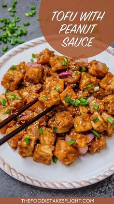 tofu with peanut sauce on a white plate with chopsticks and green onions