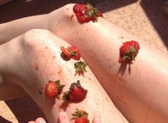 two people with strawberries on their legs