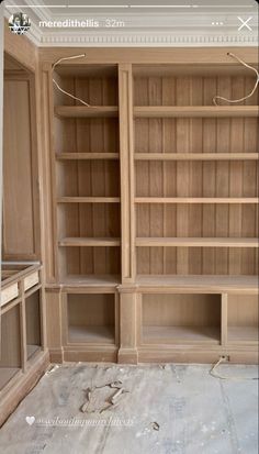 an empty bookcase in the middle of a room with no furniture on it,