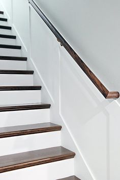 some stairs with wooden handrails and white walls