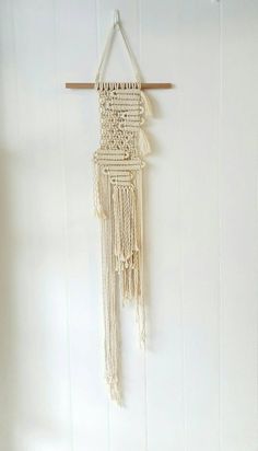 a white wall hanging with some tassels on it