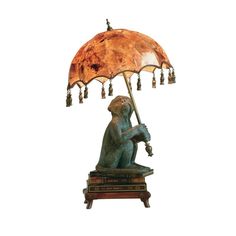 a lamp that is sitting on top of a wooden stand with a bear holding an umbrella