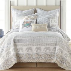 an elephant themed comforter set with pillows and pillow cases on top of the bed