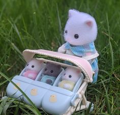 a stuffed animal in a toy car on the grass