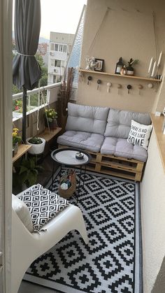 an apartment balcony with white furniture and black and white rugs