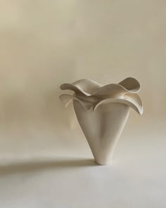 a white vase sitting on top of a table