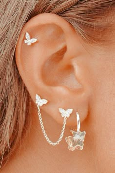 a close up of a person's ear with two butterflies on the back of it