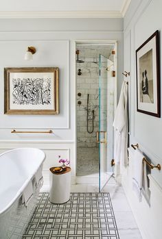 a bathroom with a tub, sink and shower in it's own area next to a painting on the wall